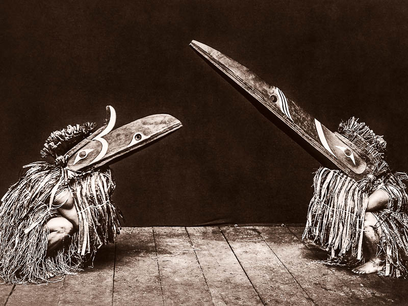 Kotsuis and Hohhug—Nakoaktok, wearing ceremonial dress, with long beaks, on their haunches, dancing
